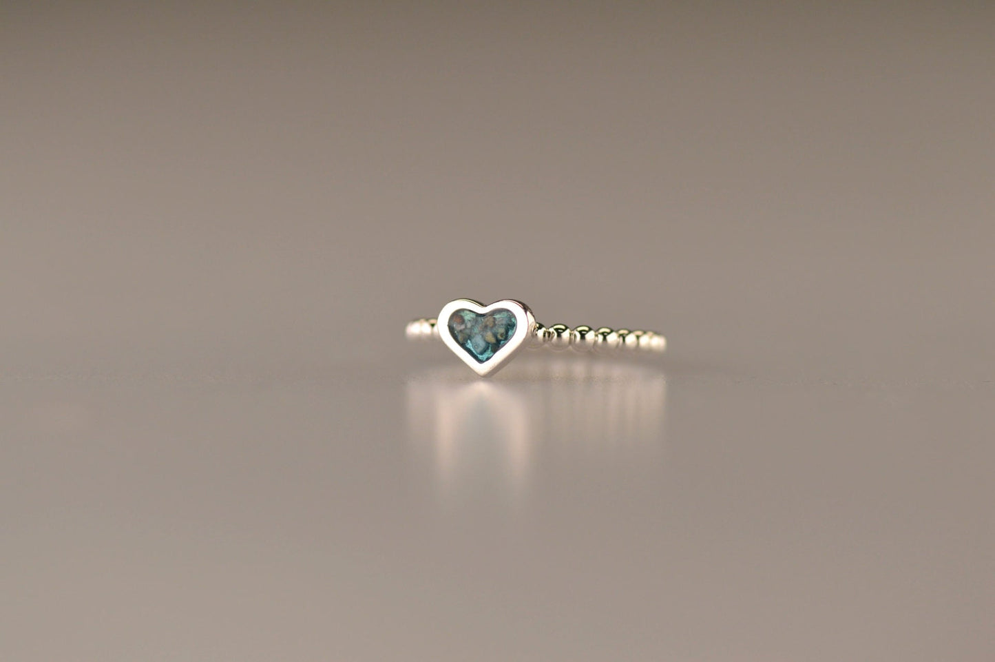 Bolletjes ring met een hartje er boven op , waar zichtbaar as of haar in verwerkt wordt.De asring is leverbaar in zilver en in 14 en 18 KT geelgoud/witgoud en roségoud.alle