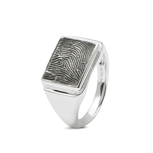 Zegelring met een rechthoekig vlak aan de voorzijde voorzien van een vingerafdruk.