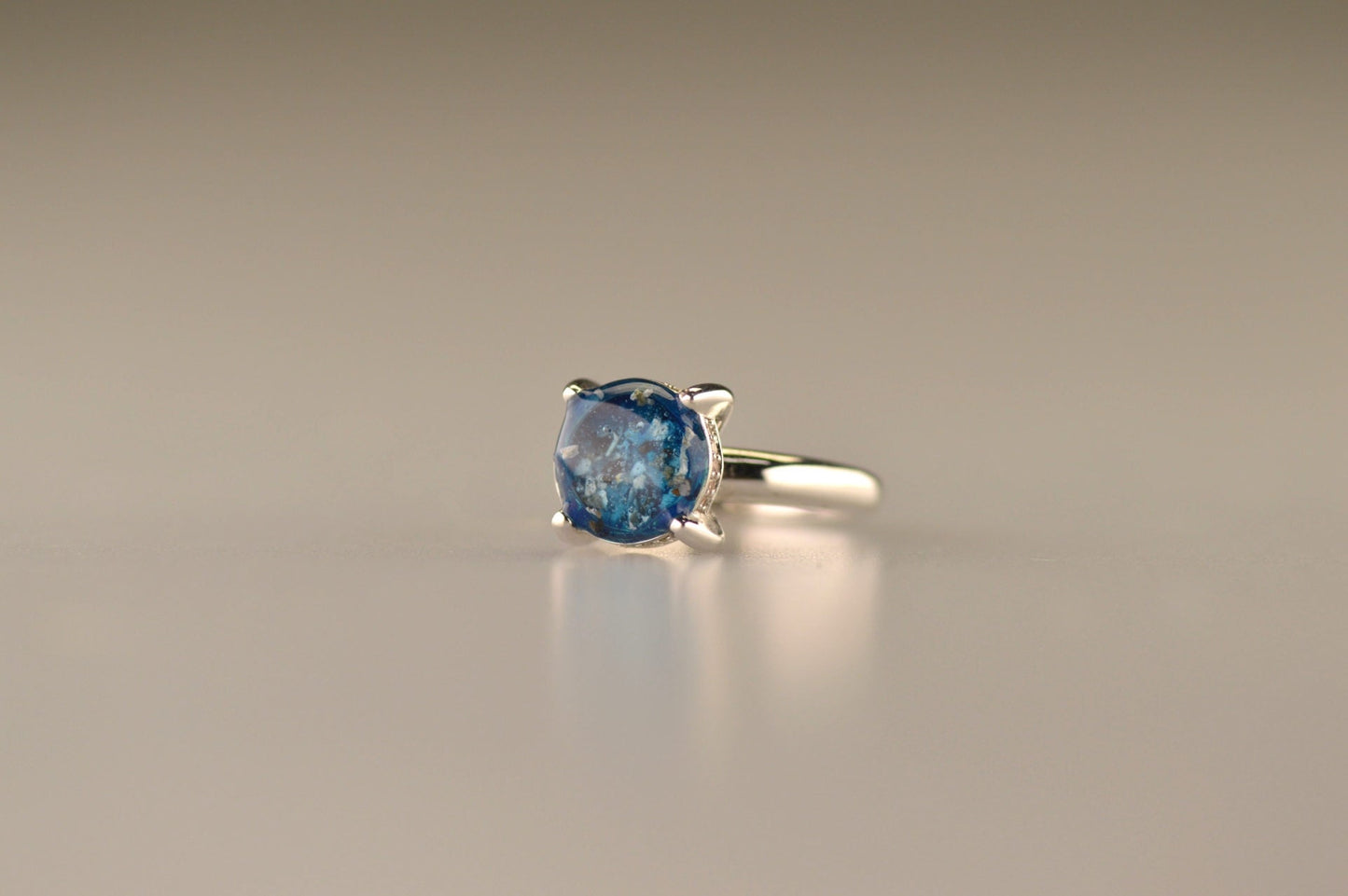 Gedenksieraad, asring 3 mm waar aan de bovenzijde zichtbaar as of haar verwerkt wordt, rondom aan de zijkant gezet met zirkonia's of diamanten naar keuze.