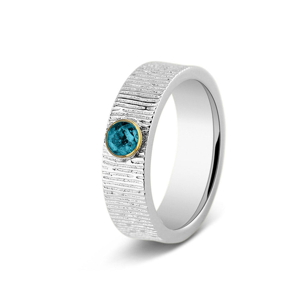 Ring 6 mm uit onze serie gedenksieraden, waar zichtbaar as of haar (of eventueel melktandjes of moedermelk) verwerkt wordt in het ronde ornamentje. Turquoise