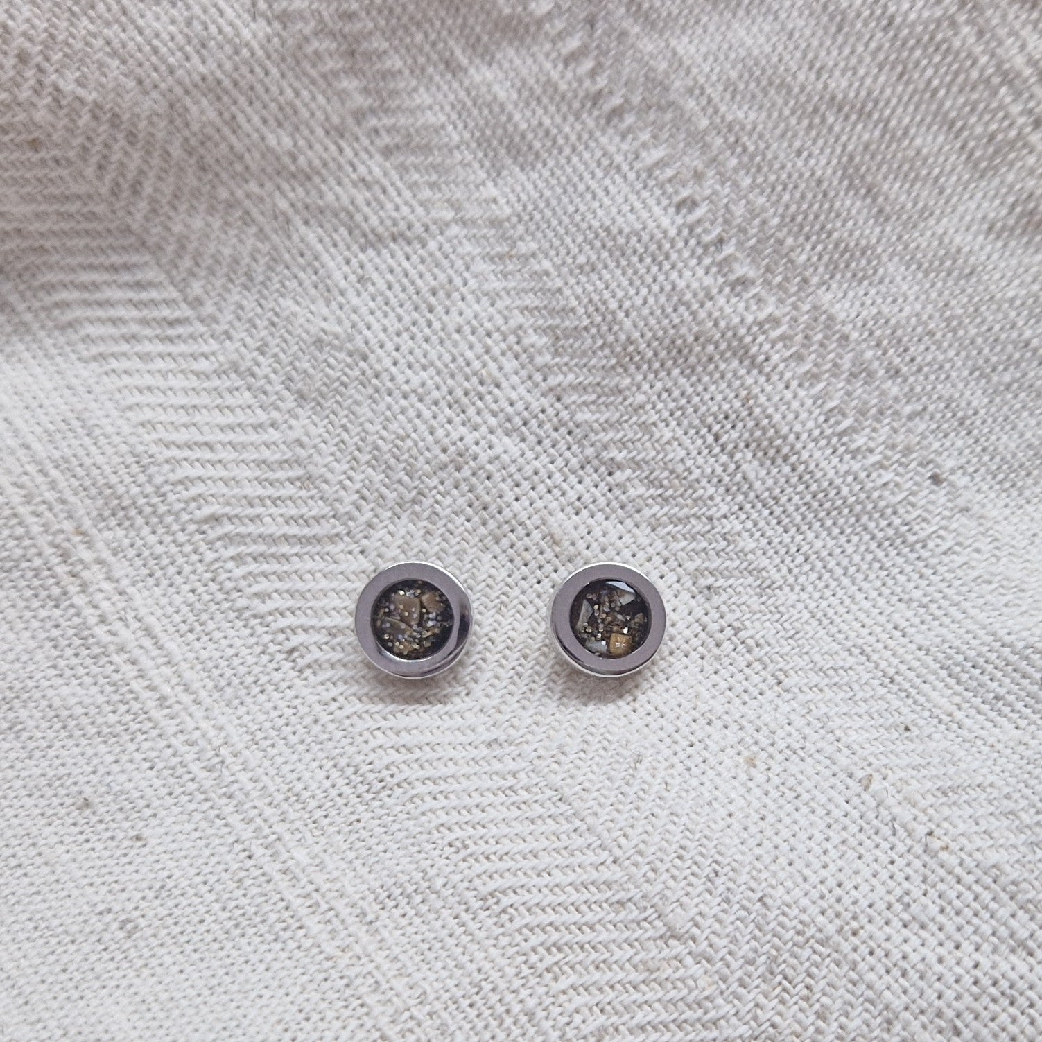 Rond gevormde oorstekers 8 mm aan de voorzijde zichtbaar gevuld met as of haar. Alle