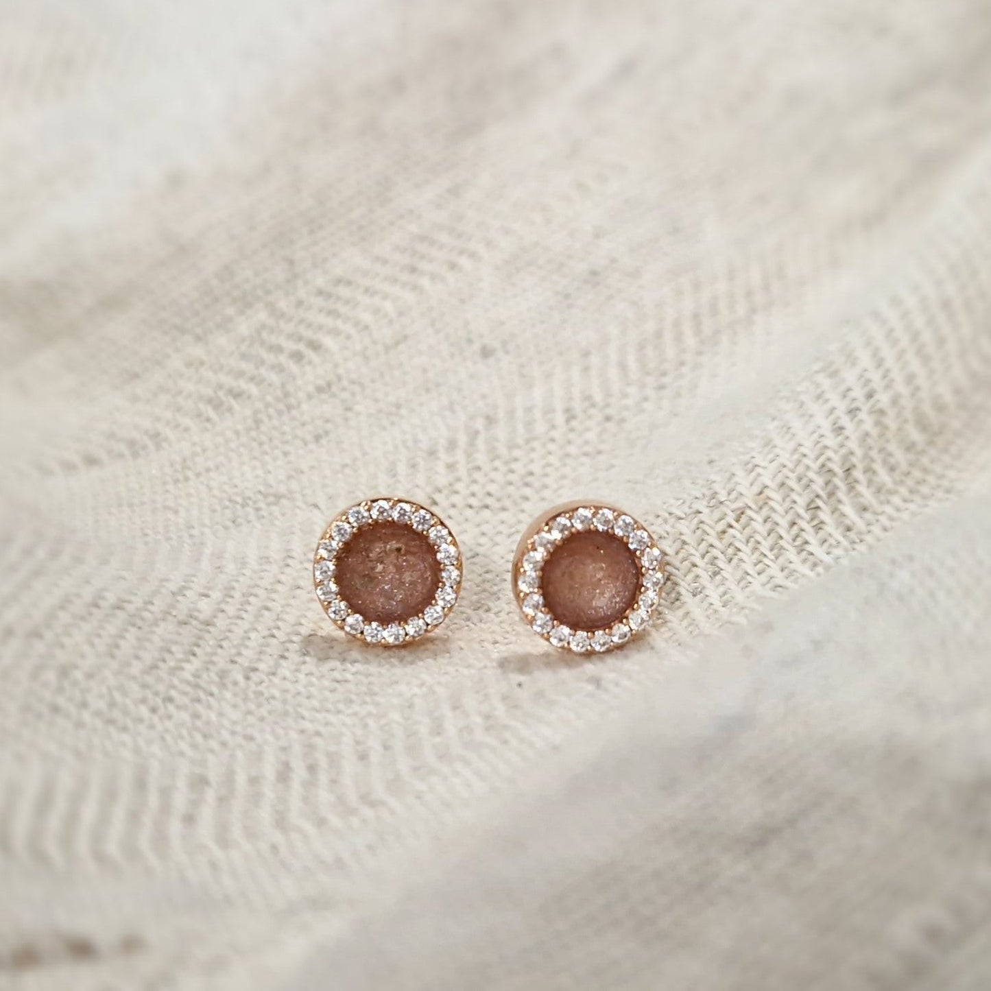 Oorstekers 8 mm rondom afgewerkt met zirkonia's zichtbaar gevuld met as of haar. Alle