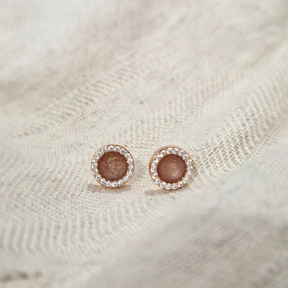 Oorstekers 8 mm rondom afgewerkt met zirkonia's zichtbaar gevuld met as of haar. Alle