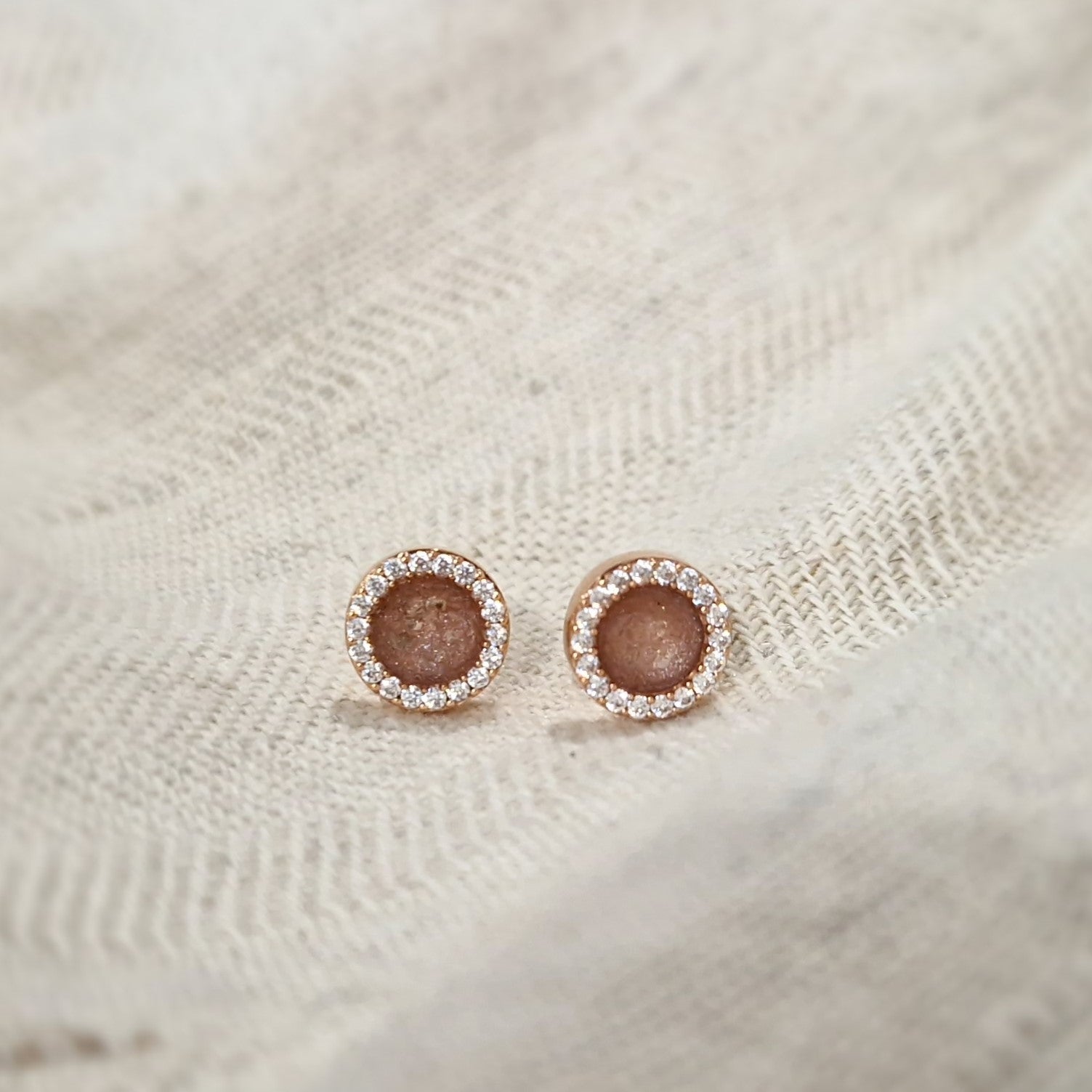 Oorstekers 8 mm rondom afgewerkt met zirkonia's zichtbaar gevuld met as of haar. Alle