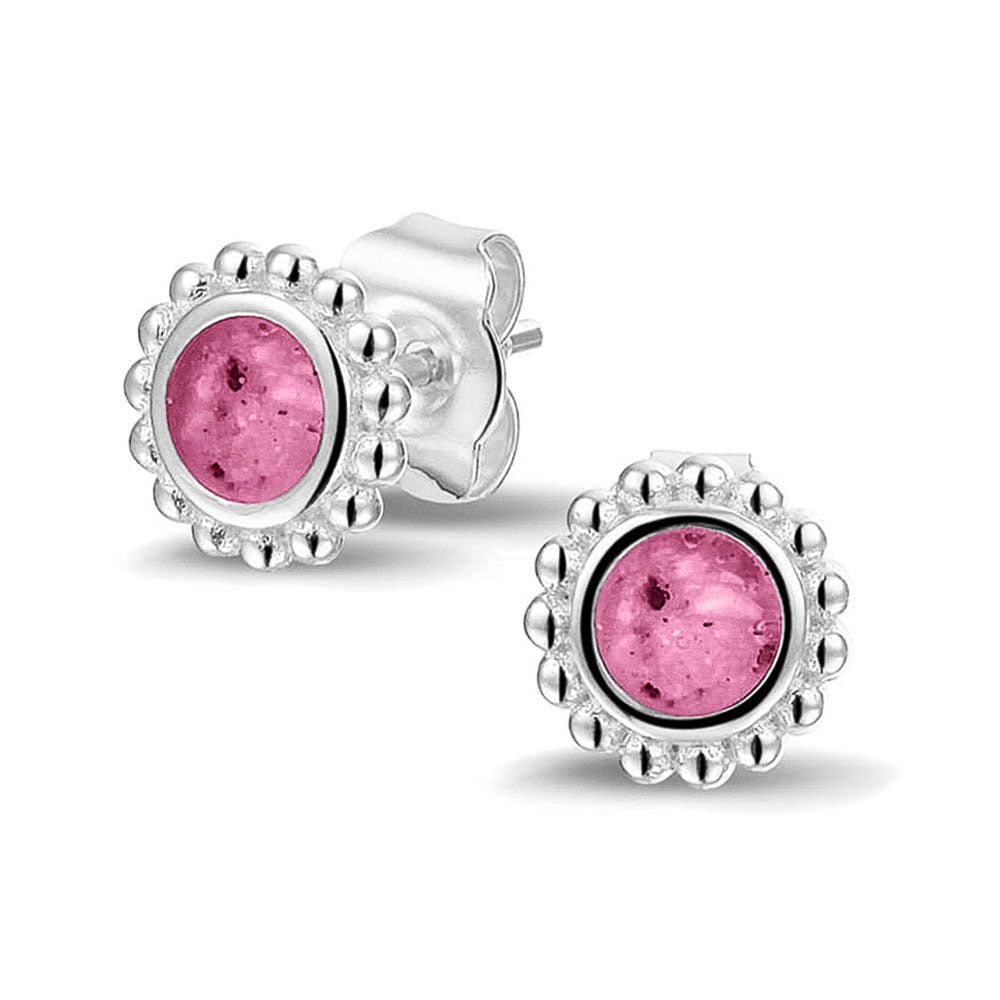 Twee stuks ronde oorstekers 8 mm zichtbaar gevuld met as of haar. Fluo