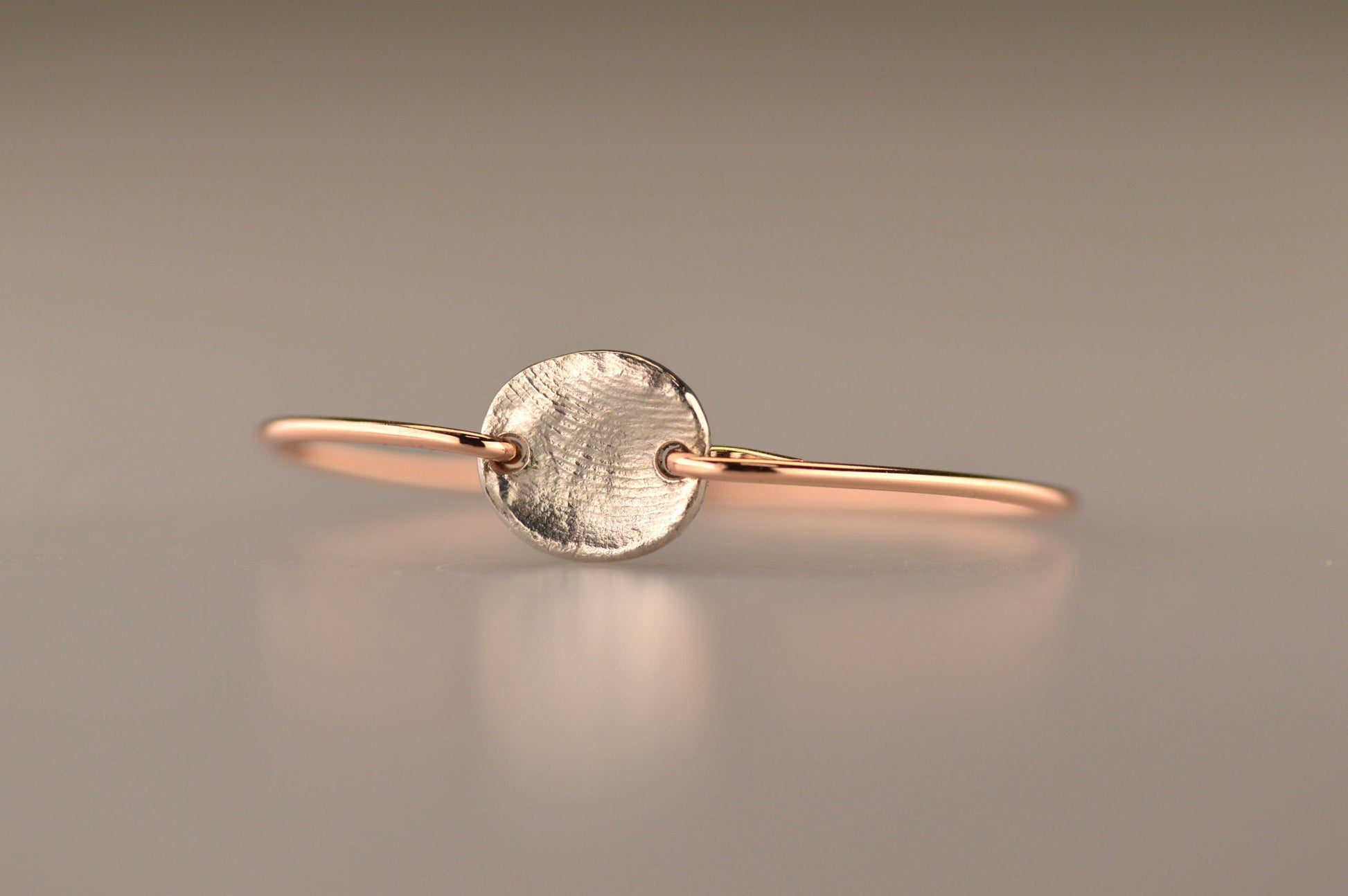 Roségouden armband met zilveren 925 sterling muntje en vingerafdruk.alle