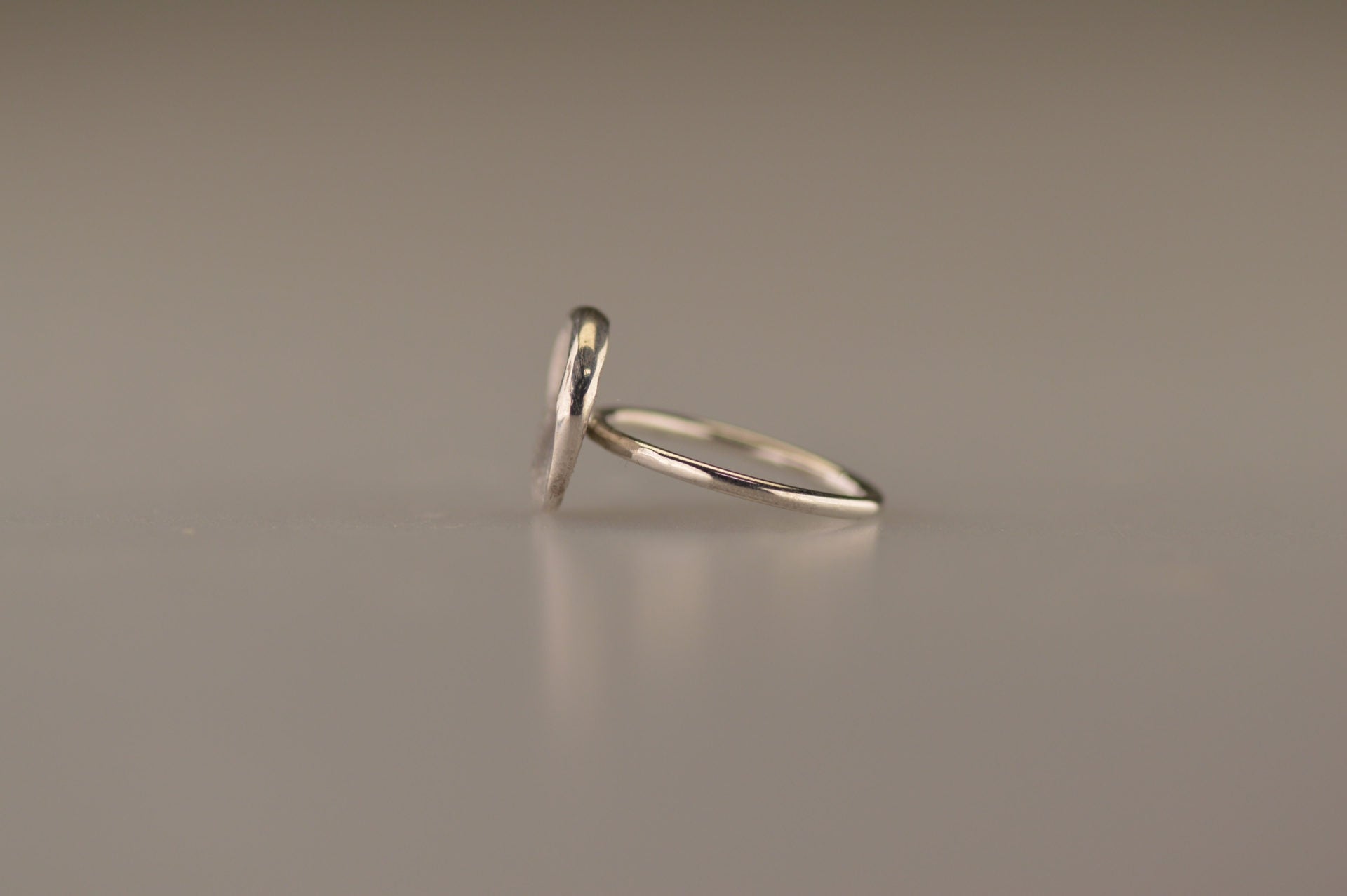 Gouden ring 1.6 mm breed met een iets hollend rond vlak aan de bovenzijde voorzien van een natuurlijke zilveren vingerafdruk. Alle