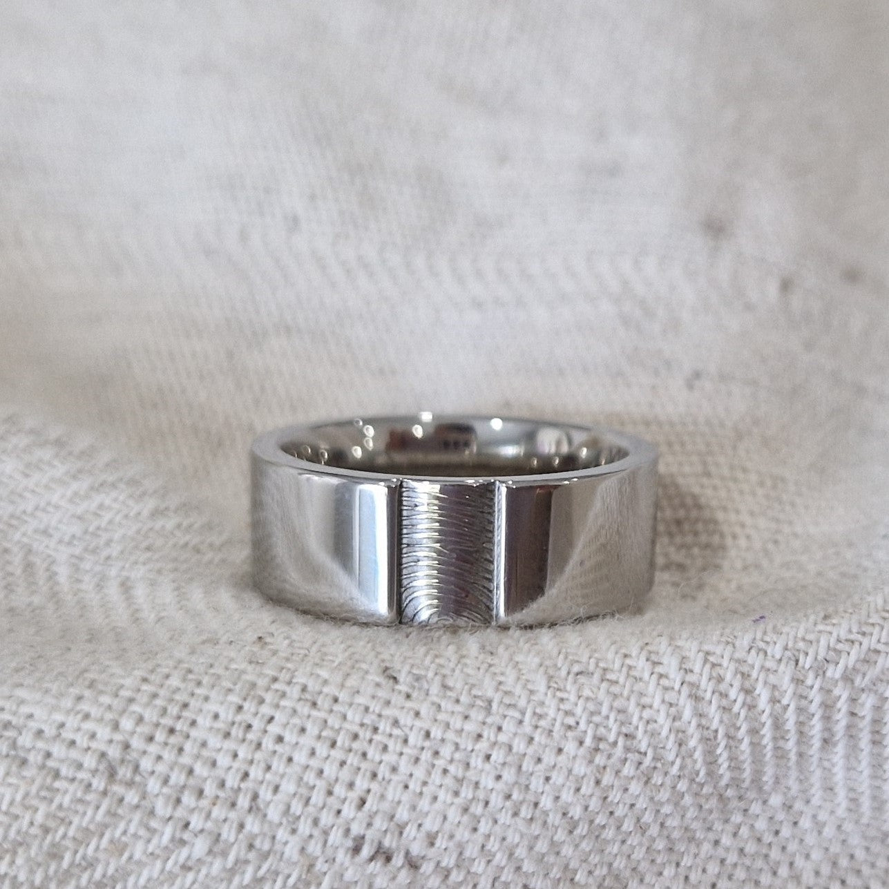 Ring 8 mm met een rechthoekig vlakje aan de voorzijde voorzien van een vingerafdruk. Alle