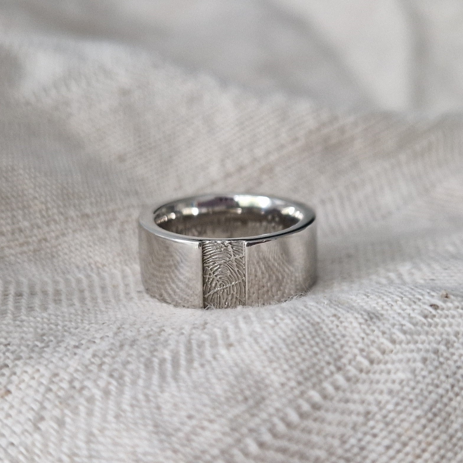 Ring 8 mm met een rechthoekig vlakje aan de voorzijde voorzien van een vingerafdruk. Alle