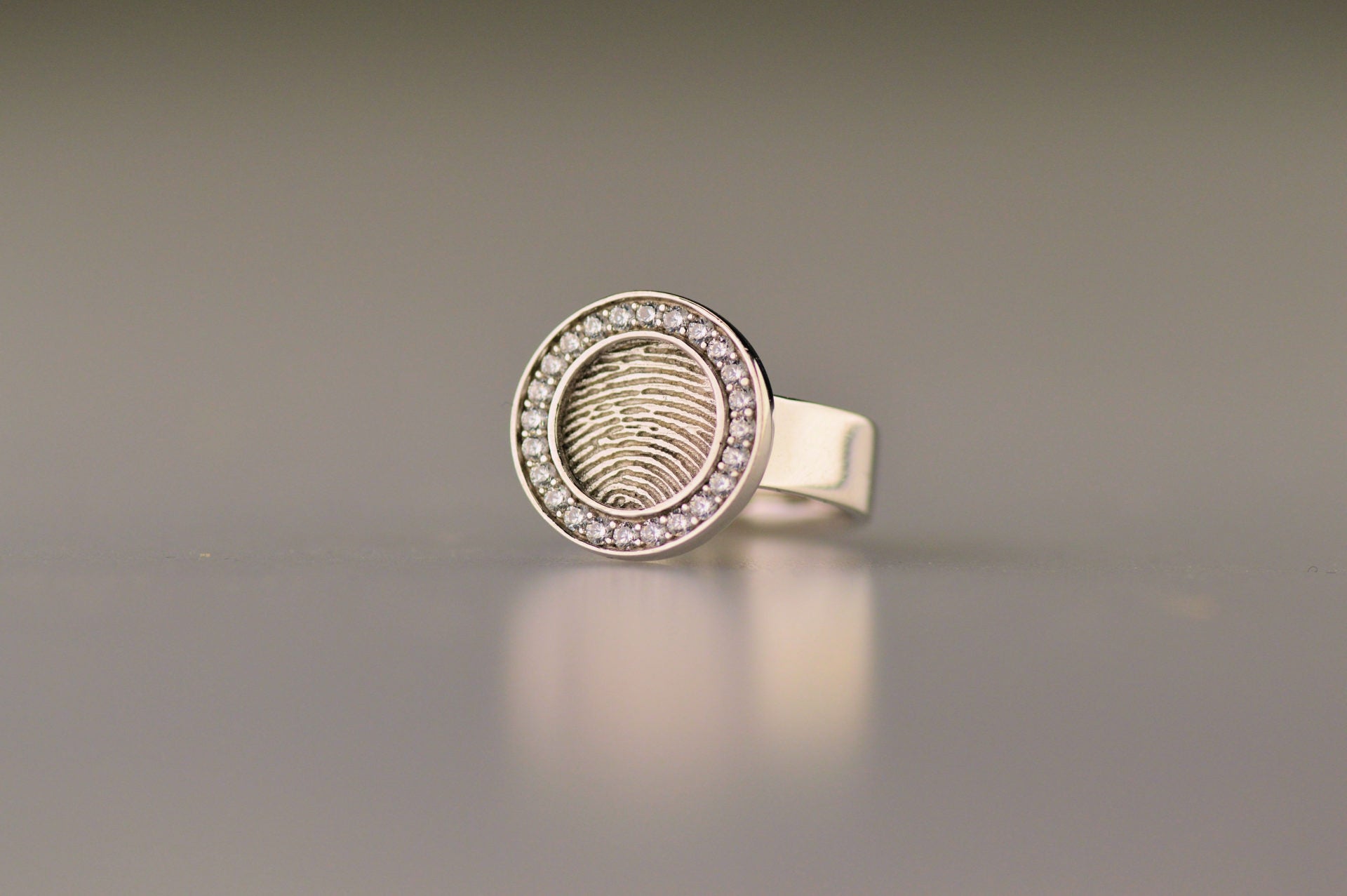 Ring 6 mm breed met een rond vlak aan de bovenzijde voorzien van een vingerafdruk