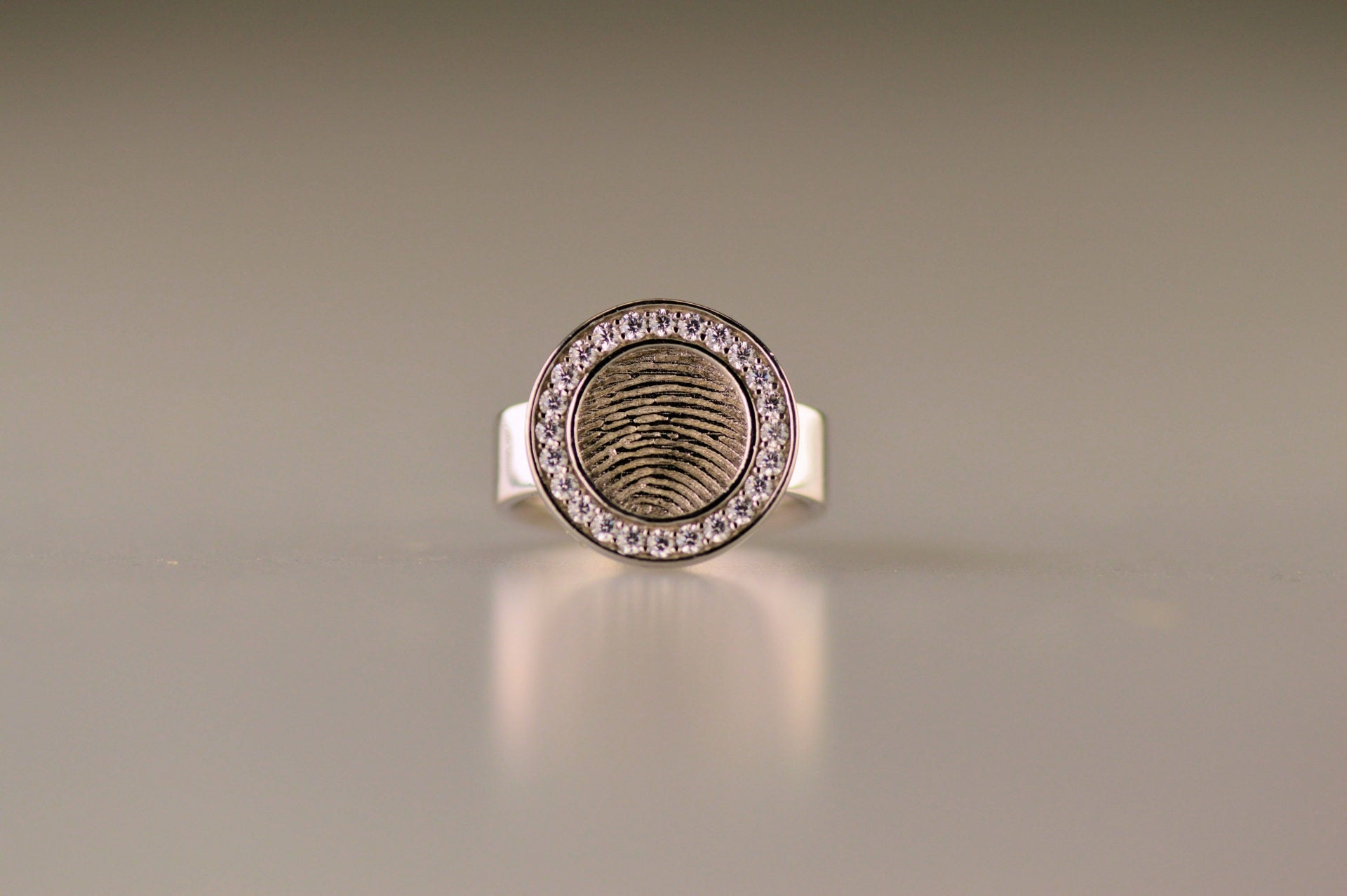 Ring 6 mm breed met een rond vlak aan de bovenzijde voorzien van een vingerafdruk