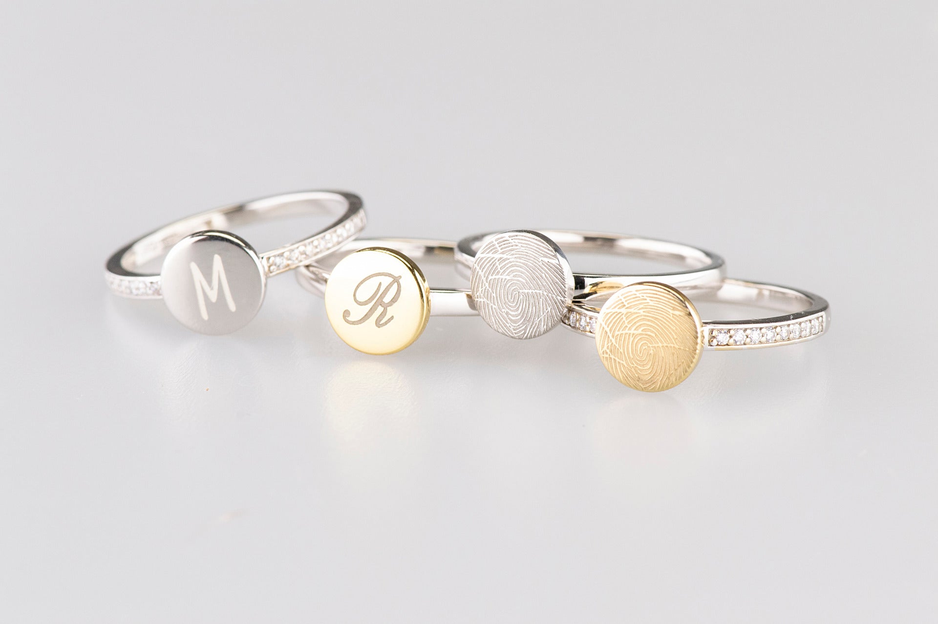 Zilveren ring voorzien van een 14 KT gouden vingerafdruk/gravure, de ringband is in de bovenste helft afgewerkt met zirkonia's. alle