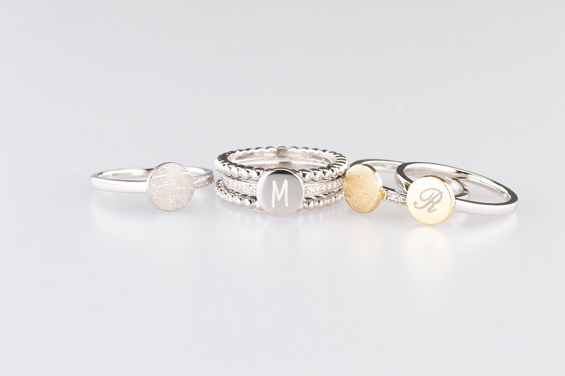 Zilveren ring voorzien van een 14 KT gouden vingerafdruk/gravure, de ringband is in de bovenste helft afgewerkt met zirkonia's. alle