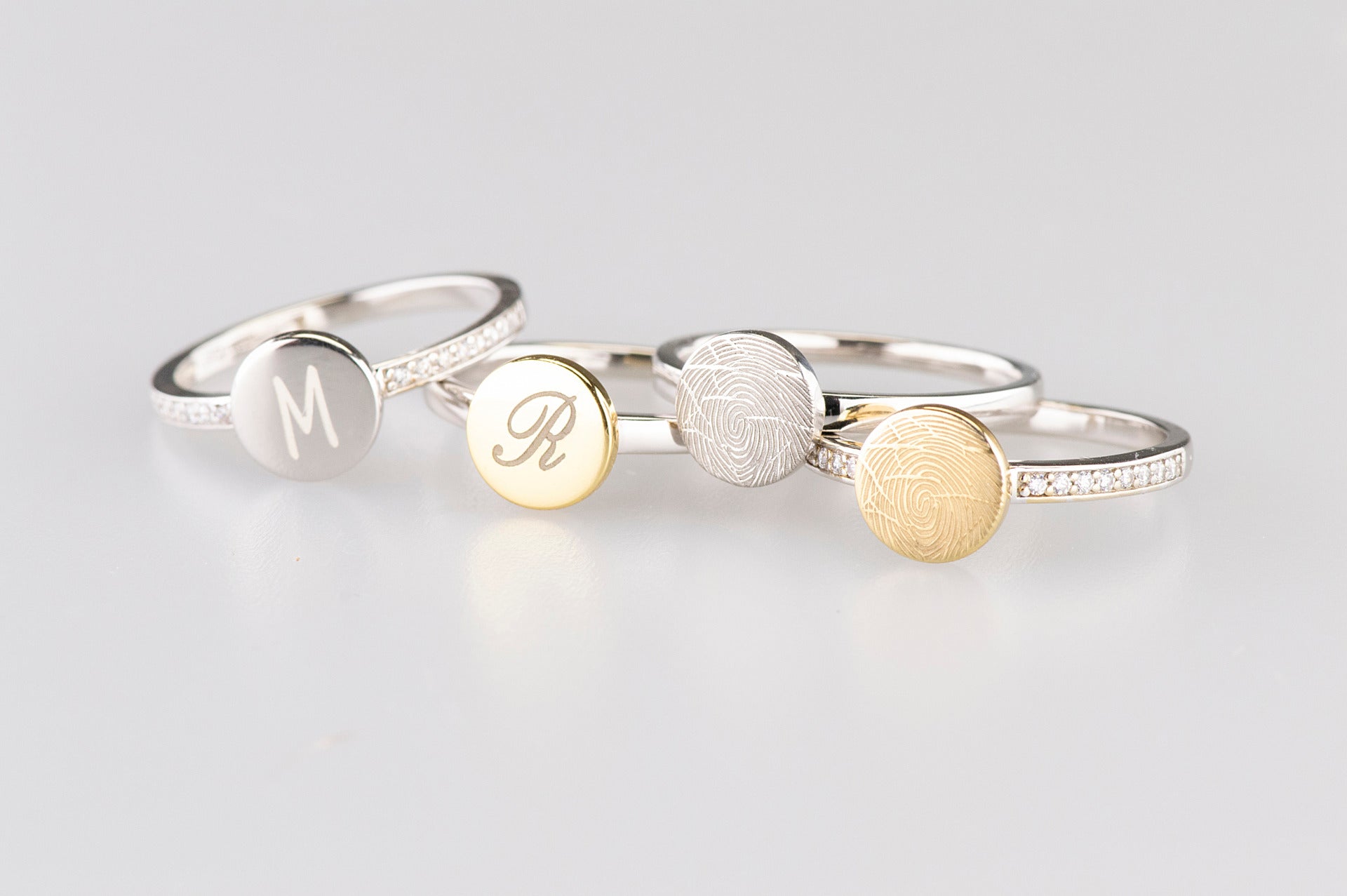 Ring 2 mm breed voorzien van een vingerafdruk/gravure, de ringband is in de bovenste helft afgewerkt met zirkonia's. alle