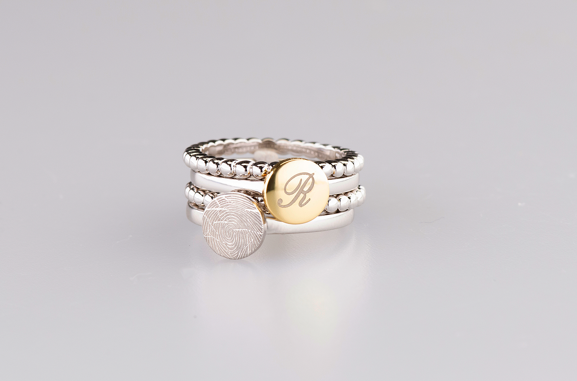 Ring 2 mm breed voorzien van een vingerafdruk/gravure, de ringband is in de bovenste helft afgewerkt met zirkonia's. alle