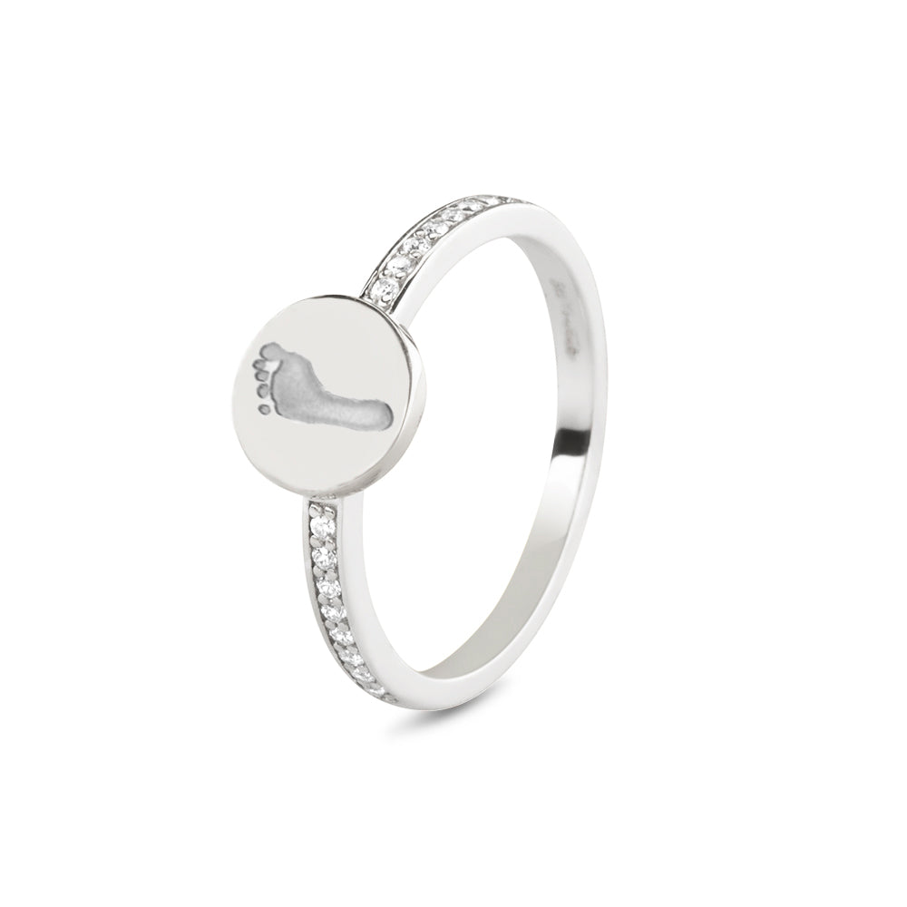 Ring witgoud 2 mm breed voorzien van een vingerafdruk/gravure, de ringband is in de bovenste helft afgewerkt met zirkonia's. witgoud