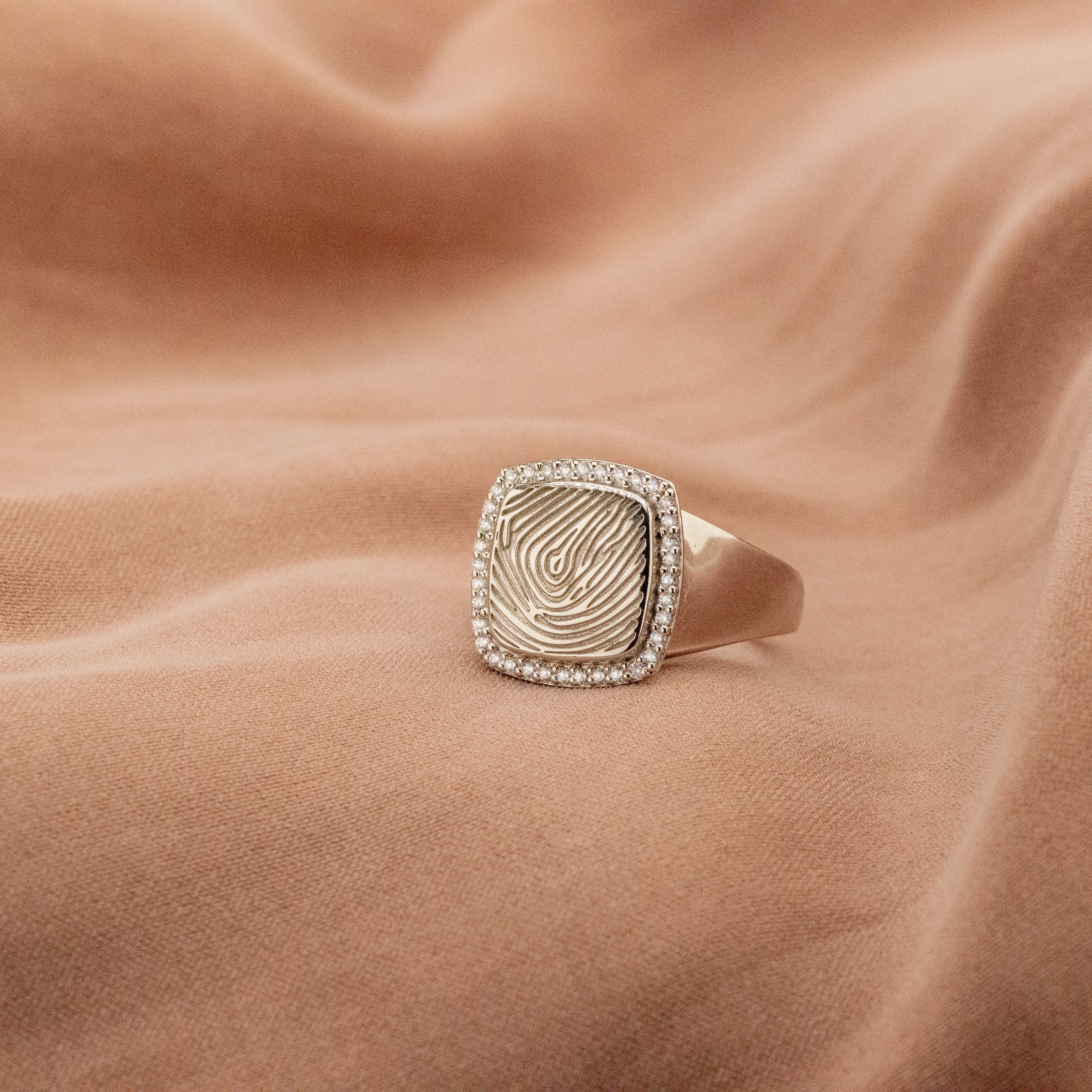 Zegelring voorzien van een gravure, rondom afgewerkt met zirkonia's. alle