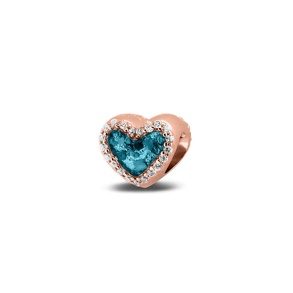 Hartvormige asbedel met  zirkonia's rondom afgewerkt, die aan beide zijdes in twee compartimenten zichtbaar gevuld wordt met as of haar met een keuze in 20 kleuren. Turquoise