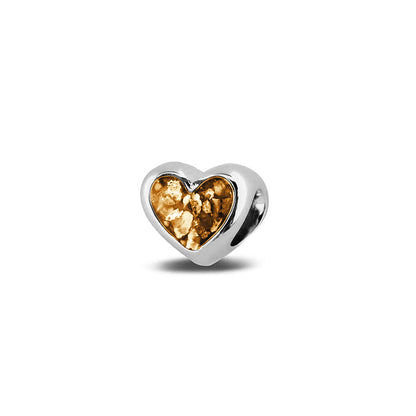 Hartvormige asbedel, aan beide zijdes zichtbaar gevuld met as of haar. Het vullen en sealen met onze speciale hars met een keuze in 20 kleuren, wordt in onze ambachtelijke edelsmederij gedaan. Gold