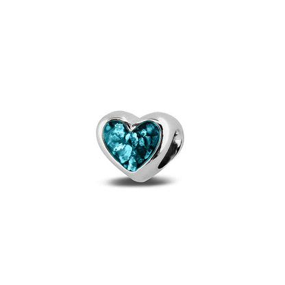 Hartvormige asbedel, aan beide zijdes zichtbaar gevuld met as of haar. Het vullen en sealen met onze speciale hars met een keuze in 20 kleuren, wordt in onze ambachtelijke edelsmederij gedaan. Turquoise