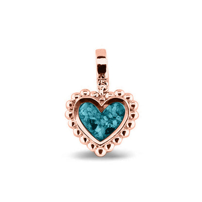Hartvormige asbedel, die aan de voorzijde zichtbaar gevuld wordt met as of haar. Het vullen en sealen met een keuze in 20 kleuren, wordt in onze ambachtelijke edelsmederij gedaan. Turquoise