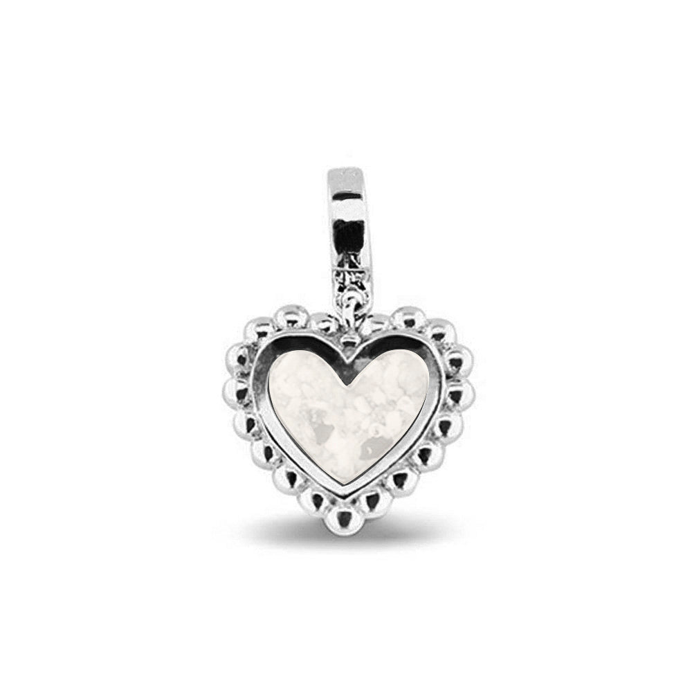 Hartvormige asbedel, die aan de voorzijde zichtbaar gevuld wordt met as of haar. Het vullen en sealen met een keuze in 20 kleuren, wordt in onze ambachtelijke edelsmederij gedaan. White