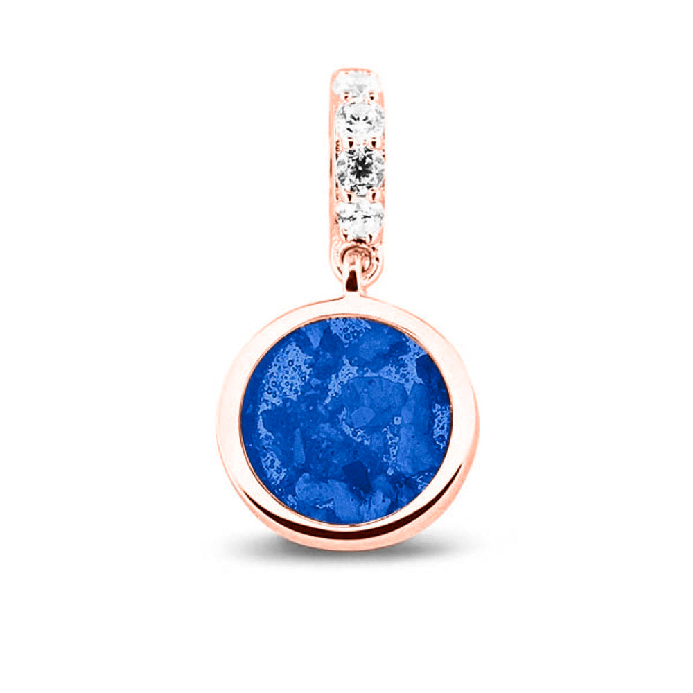 Asbedel rond subtiel design , het hangoog aan de buitenrand afgewerkt met zirkonia's, die aan de voorzijde zichtbaar gevuld wordt met as of haar met een keuze in 20 kleuren. Blue