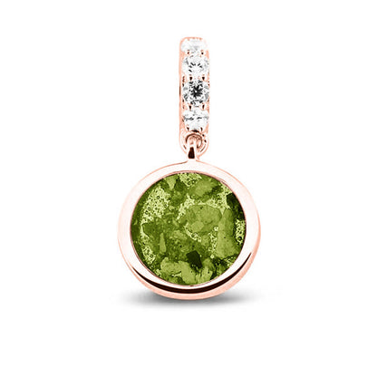 Asbedel rond subtiel design , het hangoog aan de buitenrand afgewerkt met zirkonia's, die aan de voorzijde zichtbaar gevuld wordt met as of haar met een keuze in 20 kleuren. Green