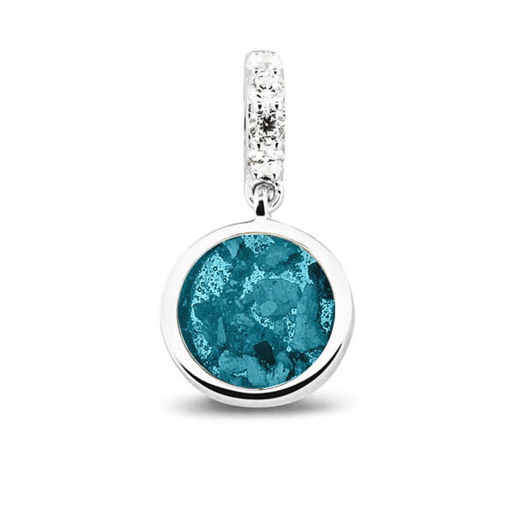 Asbedel rond subtiel design , het hangoog aan de buitenrand afgewerkt met zirkonia's, die aan de voorzijde zichtbaar gevuld wordt met as of haar met een keuze in 20 kleuren. Turquoise