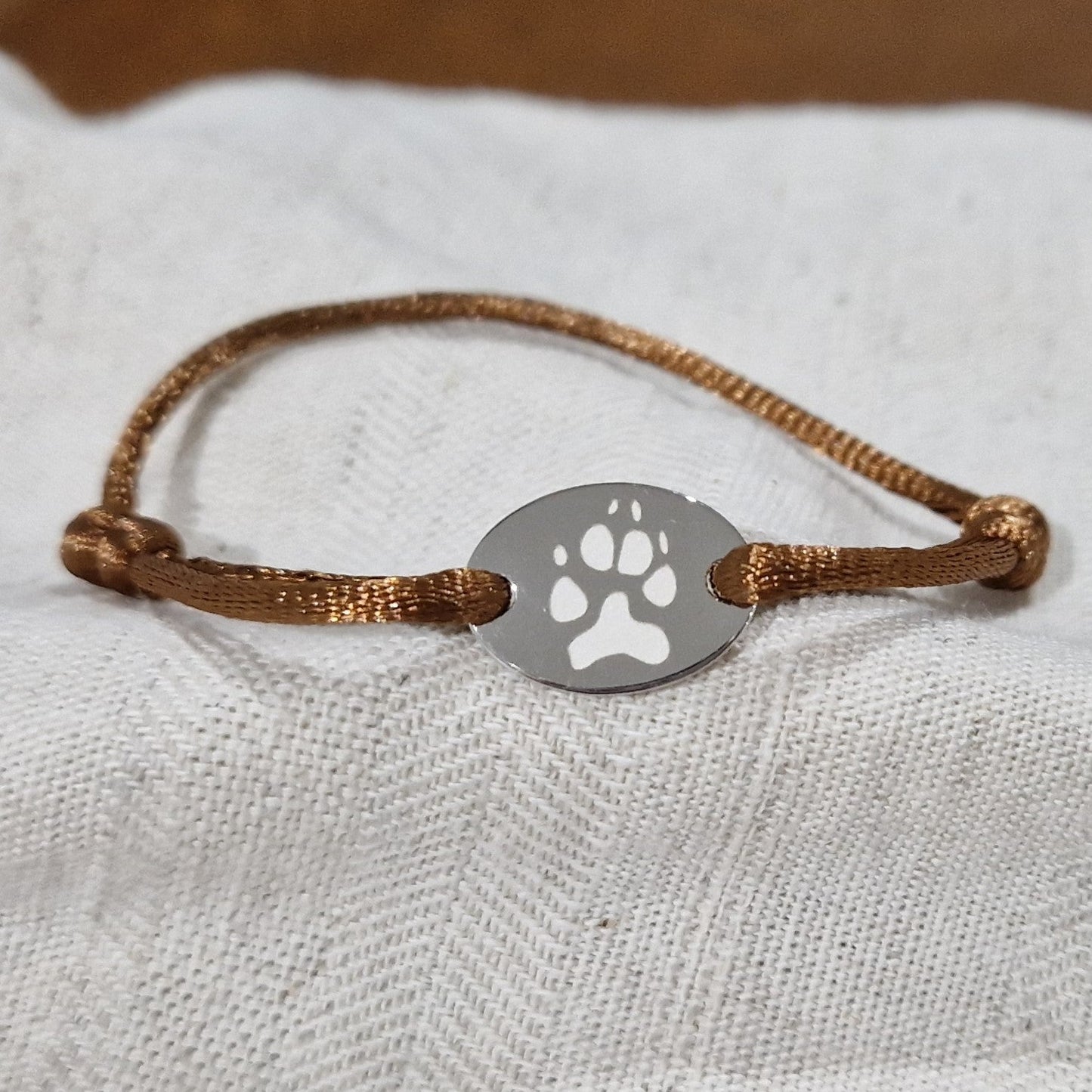 Satijnen koord armband, met ovaal graveerplaatje aan de voorzijde. Alle