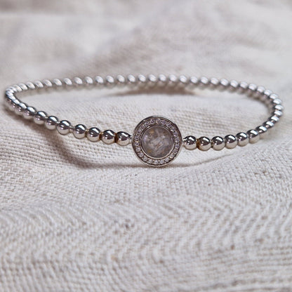 Flexibele as armband met rondje als compartiment gezet rondom met zirconia's voor as of haar. Alle