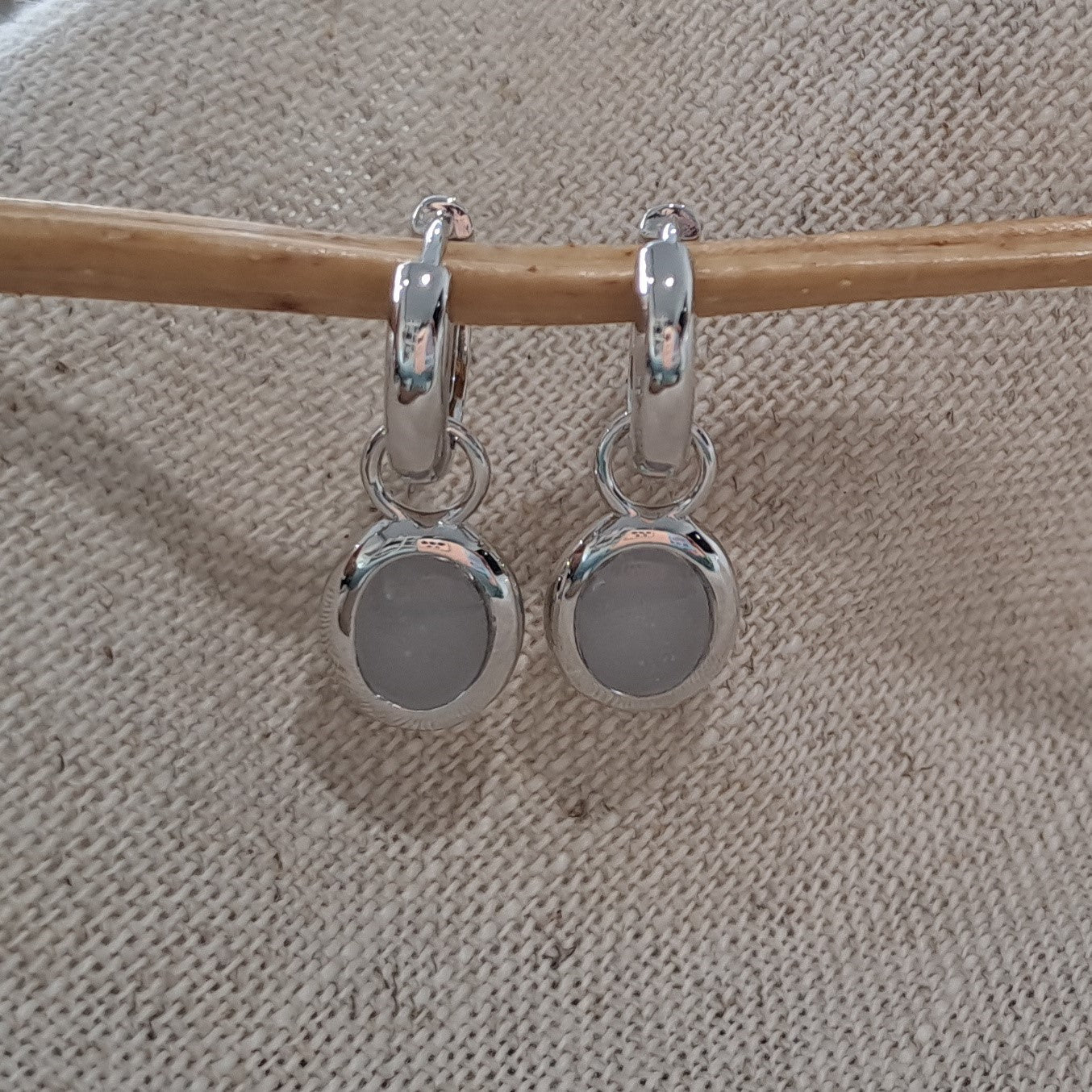 Oorhangers 17 mm lang, aan de voorzijde zichtbaar gevuld met as of haar.  Alle