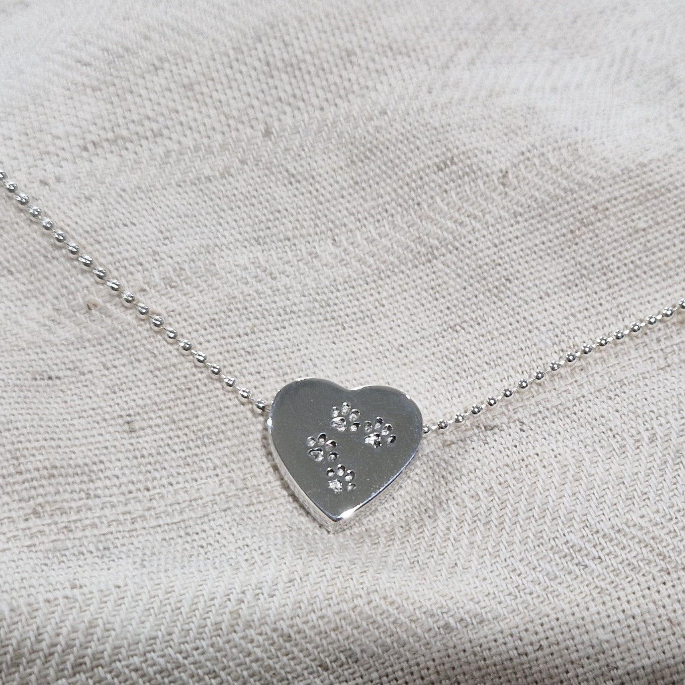 Deze zilveren 925 sterling ashanger met pootafdruk kenmerkt zich door het fraai en speels ontworpen karakter. Dit gedenksieraad kan met as en ook met haar van je huisdier gevuld worden. 