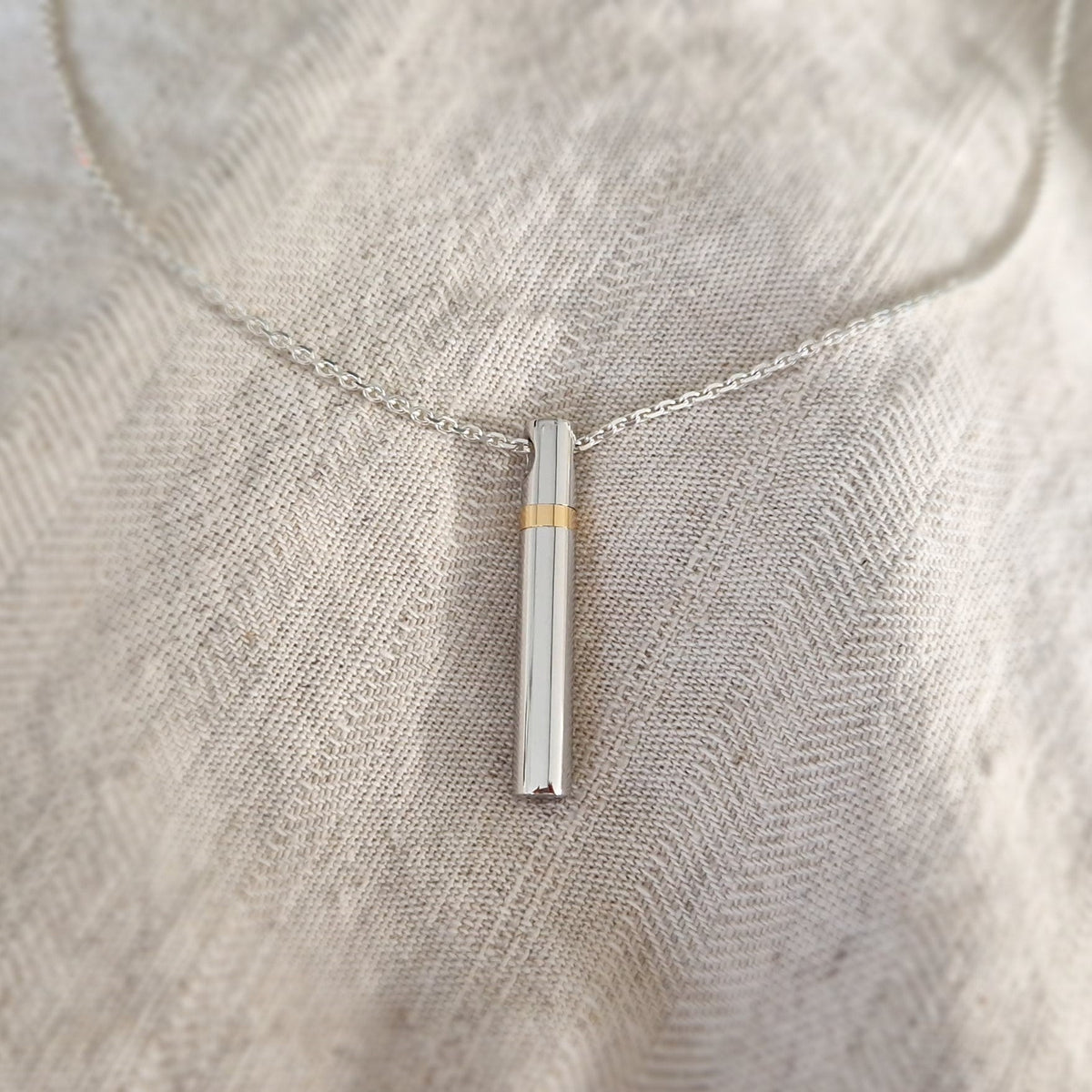 Hanger in buisvorm , de sluitring is gemaakt van 14 KT goud. De ashangers uit deze collectie gedenksieraden zijn zelf te vullen en te bestellen in zilver 925 sterling, geelgoud en witgoud.