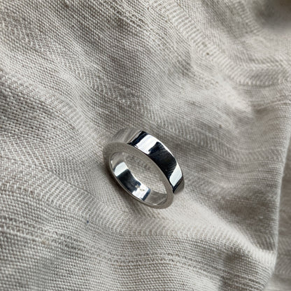 Deze asring van 6 mm breedte met vingerafdruk is heeft een subtiel weggewerkt askamertje, waar een symbolische hoeveelheid as of haar in kan bewaard worden. Alle