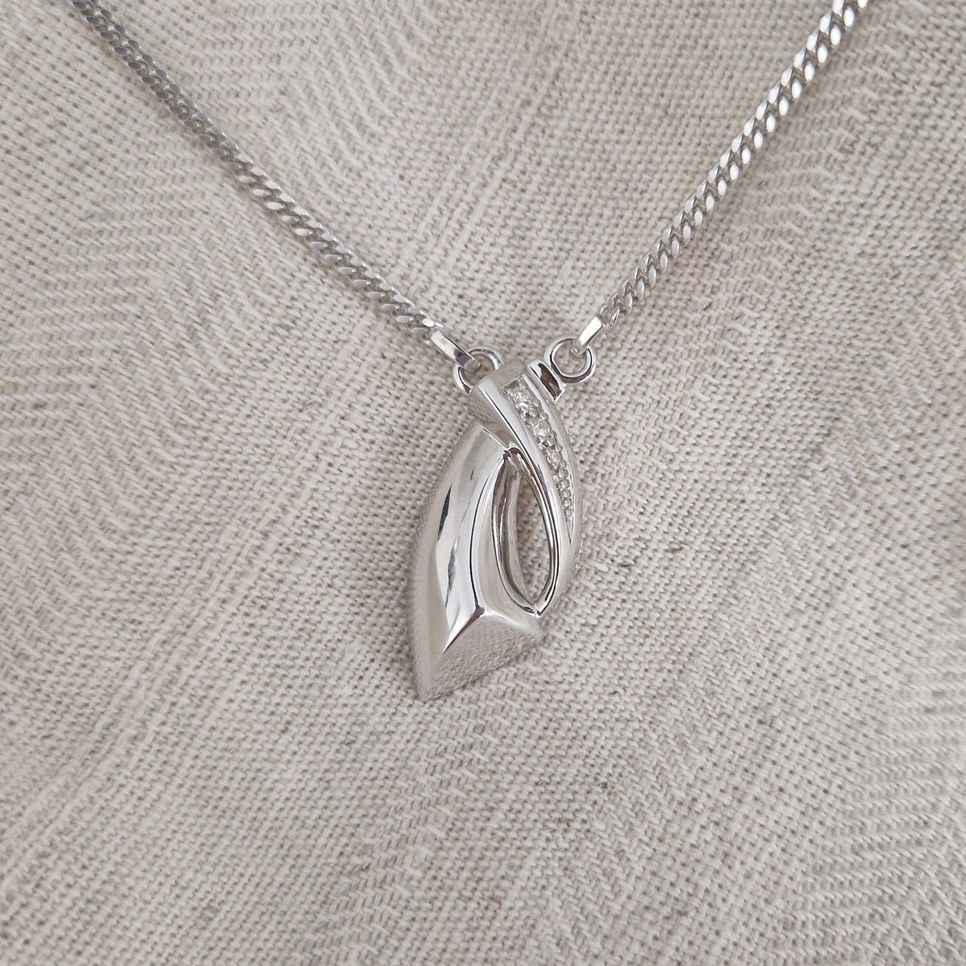 Deze ashanger wordt compleet geleverd met een 45 cm gourmette collier vast aan de hanger. In zilver afgewerkt met zirkonia's, in goud met diamanten. Alle