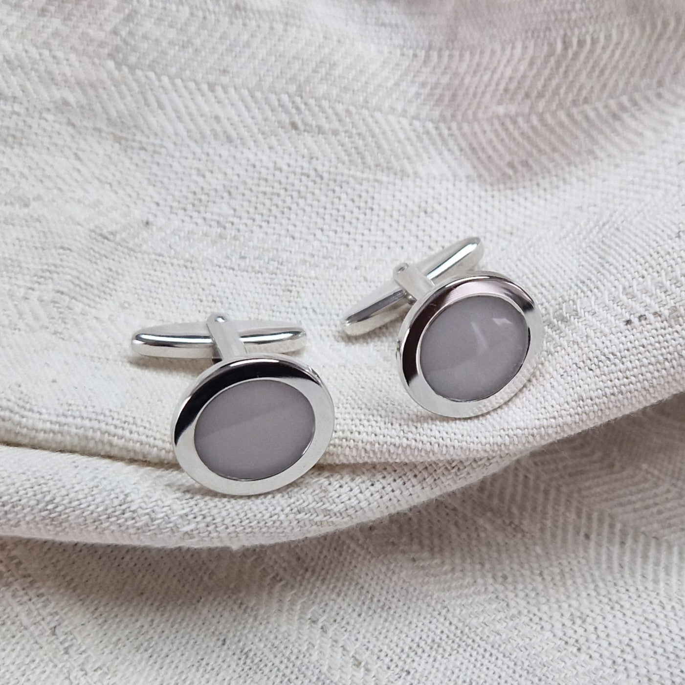 Ronde manchetknopen met as, zichtbaar gevuld, als herinneringssieraad. Alle