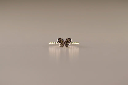 Afmeting vlinder: 8x6 mm, Ringband: 2 mm. Bolletjes ring als gedenksieraad met een vlinder er boven op , waar zichtbaar as of haar  in verwerkt wordt. Alle