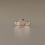 Gedenksieraad, asring met gedraaide scheen waar aan de bovenzijde in druppelvorm met parelrand zichtbaar as of haar (of eventueel melktandjes of moedermelk) verwerkt wordt.alle