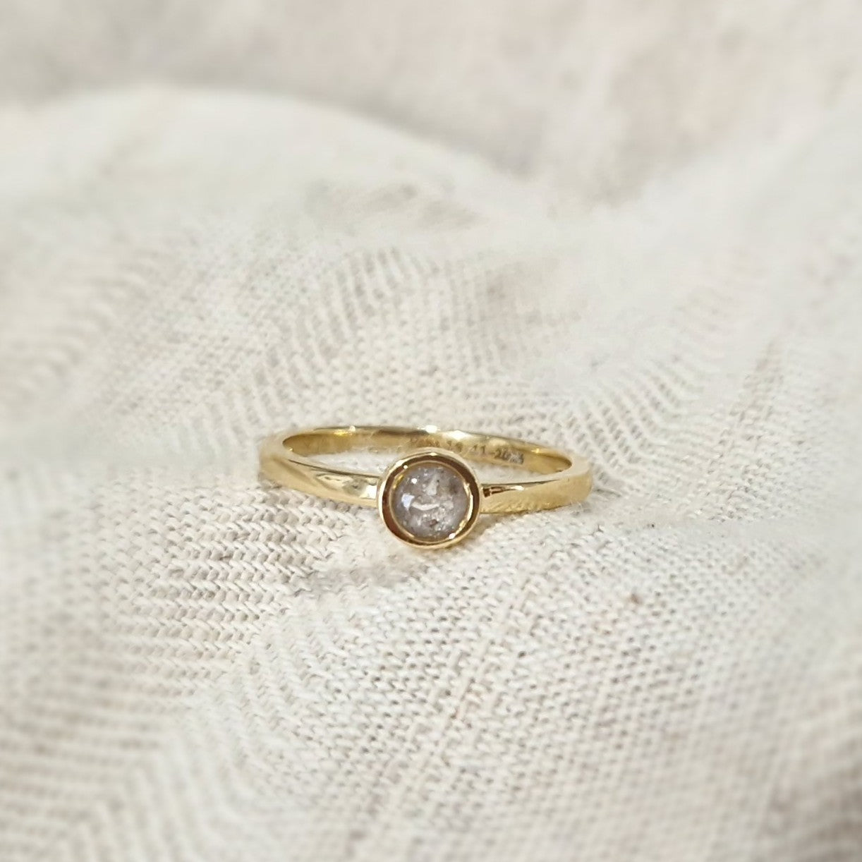 Diameter rondje: 6 mm, Ringband: 2 mm. Gedenksieraad, ring met een rondje er boven op , waar zichtbaar as of haar  in verwerkt wordt. 