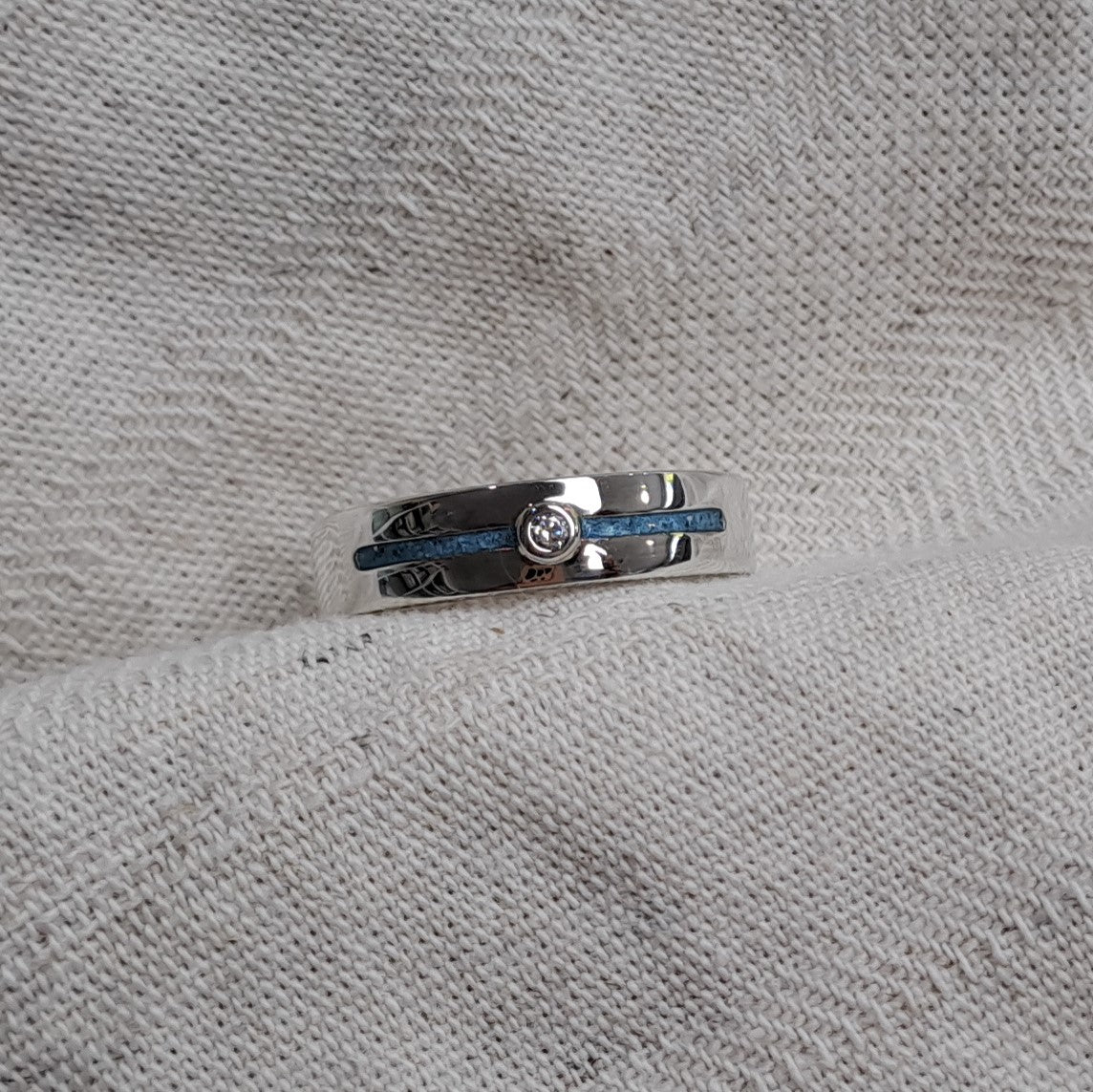 Asring 5 mm uit onze serie gedenksieraden, waar zichtbaar as of haar verwerkt wordt in twee separate compartimenten met in het midden een zirkonia of diamant naar keuze. Alle