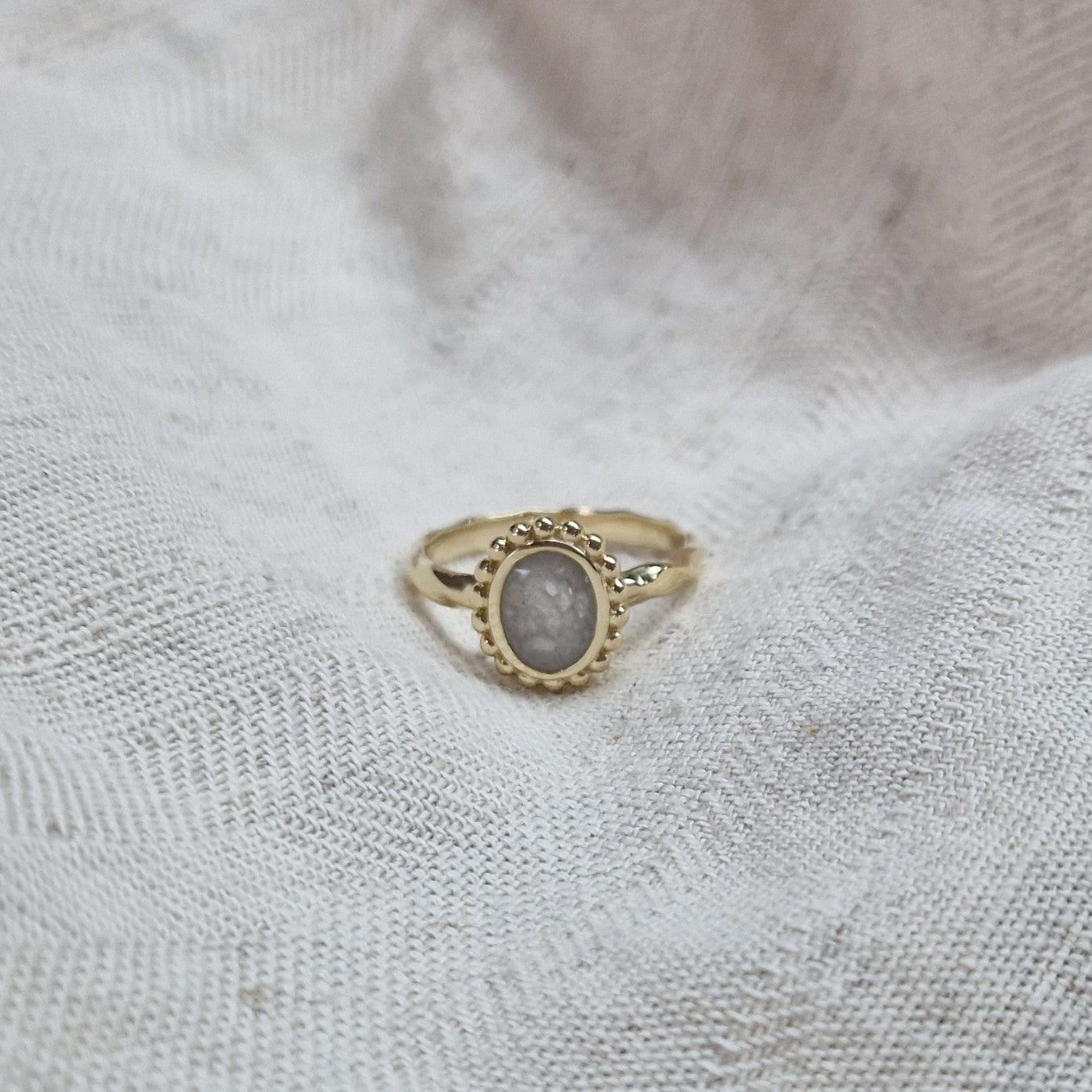 Gedenksieraad, asring met gedraaide scheen waar aan de bovenzijde in ovaalvorm met parelrand zichtbaar as of haar (of eventueel melktandjes of moedermelk) verwerkt wordt. Alle