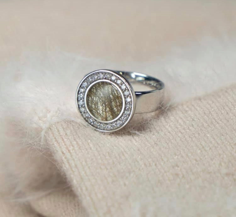 Asring 6 mm uit onze serie gedenksieraden, waar aan de bovenzijde zichtbaar as of haar verwerkt wordt in een rondje, rondom gezet met zirkonia's of diamanten naar keuze. Alle