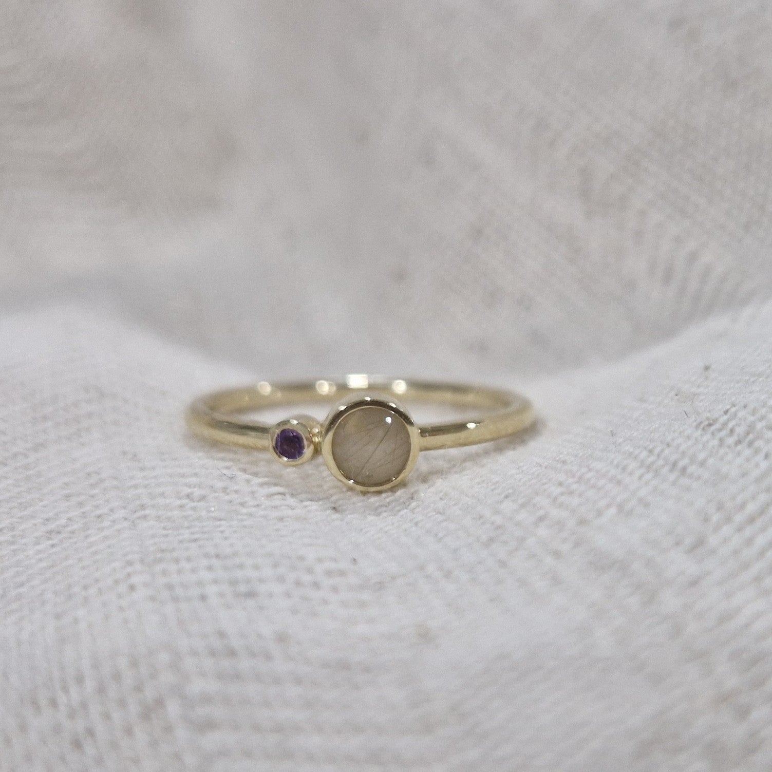 Gedenksieraad waarin een geboortesteen geplaatst wordt naar keuze. Het grotere ronde compartiment van 6 mm wordt zichtbaar gevuld met as,haar of moedermelk. alle