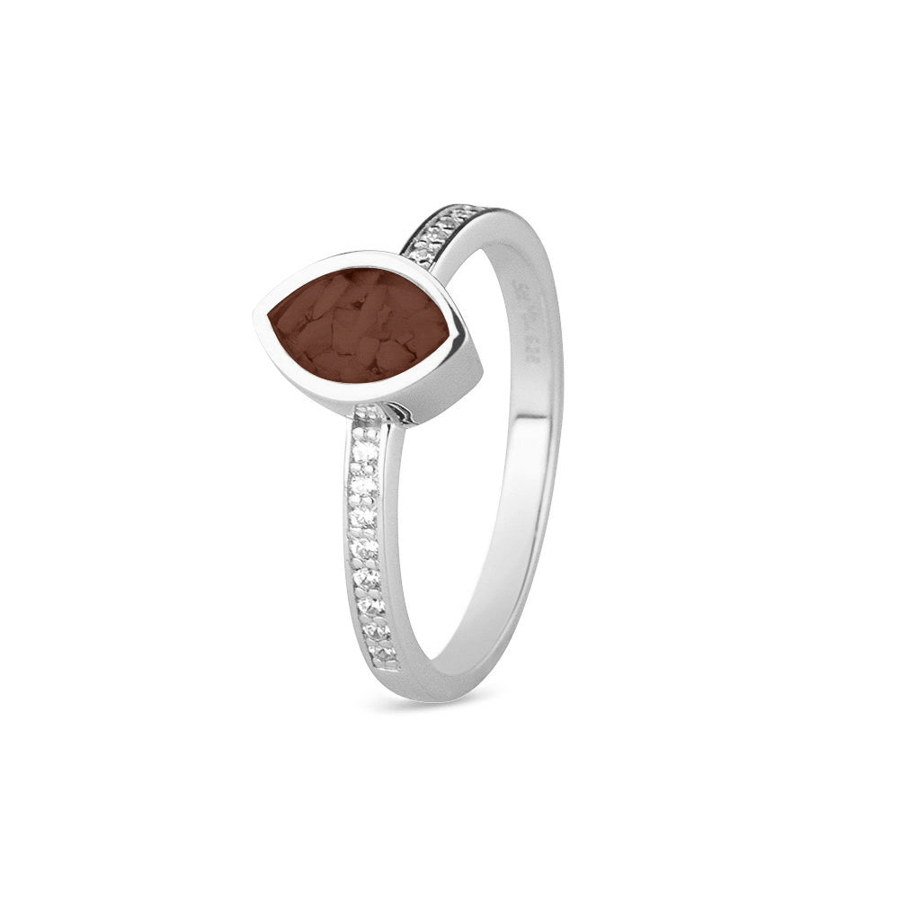 Gedenksieraad, ring 3 mm breed waar aan de bovenzijde zichtbaar as of haar verwerkt wordt. In de ringband zijn subtiel edelstenen naar keuze gezet. Brown