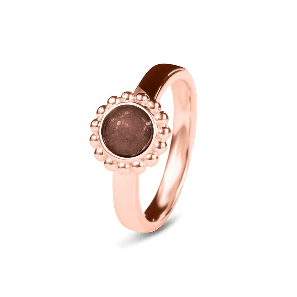 Breedte 4 mm, Diameter bovenzijde: 9.5 mm. Gedenksieraad, asring met parelrand waar aan de bovenzijde zichtbaar as of haar verwerkt wordt. Brown