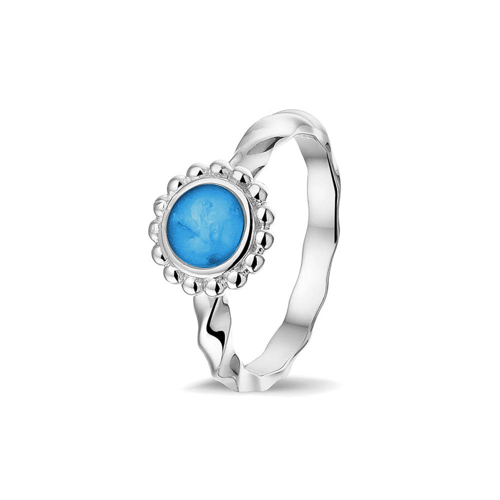 Gedenksieraad, asring 4 mm waar aan de bovenzijde in ovaalvorm met parelrand zichtbaar as of haar (of eventueel melktandjes of moedermelk) verwerkt wordt. Marine