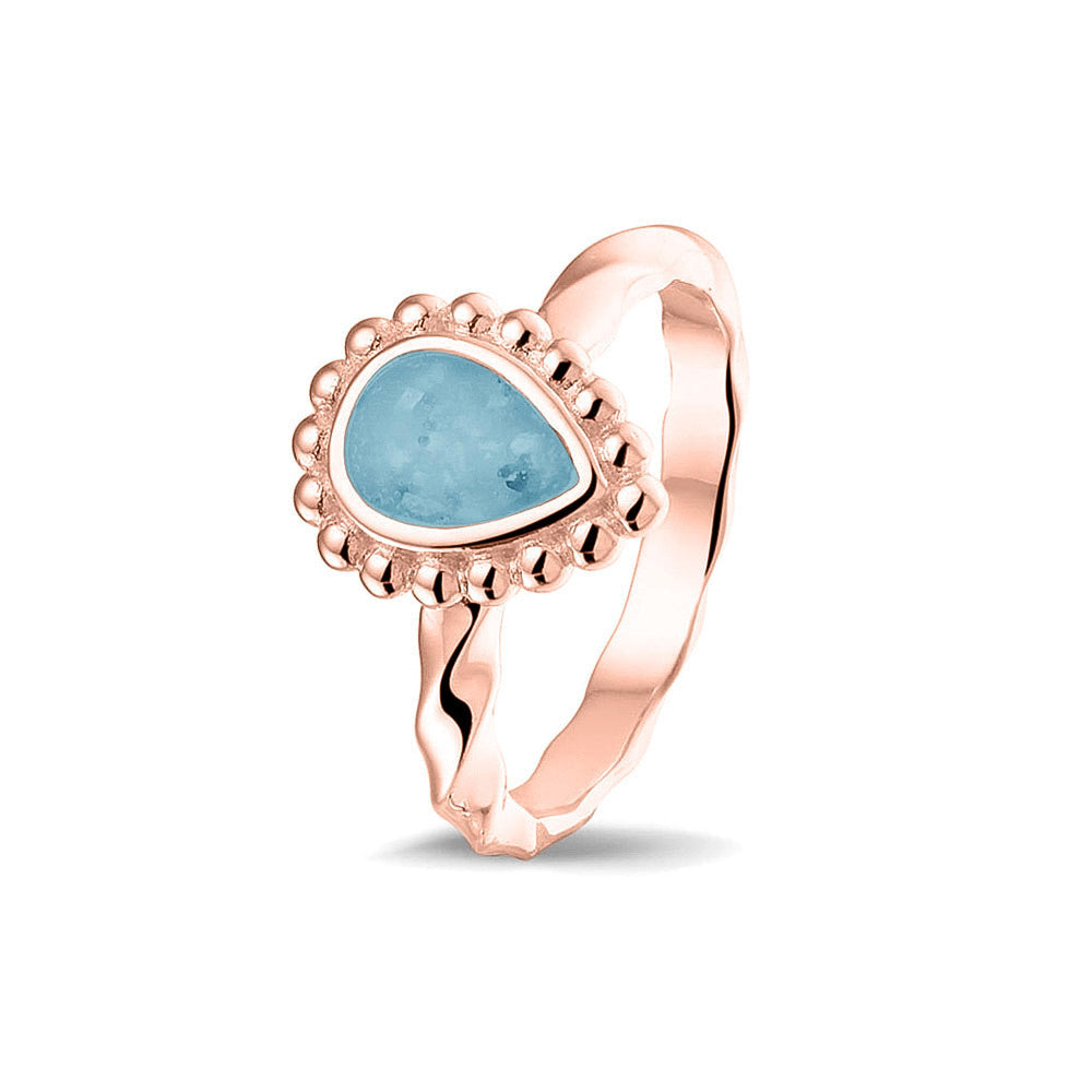 Gedenksieraad, asring met gedraaide scheen waar aan de bovenzijde in druppelvorm met parelrand zichtbaar as of haar (of eventueel melktandjes of moedermelk) verwerkt wordt.baby