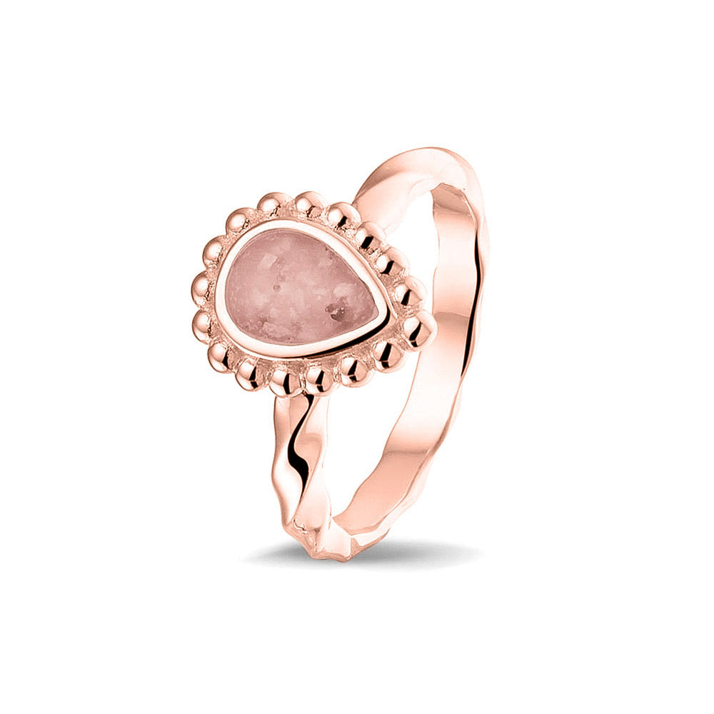 Gedenksieraad, asring met gedraaide scheen waar aan de bovenzijde in druppelvorm met parelrand zichtbaar as of haar (of eventueel melktandjes of moedermelk) verwerkt wordt.blush