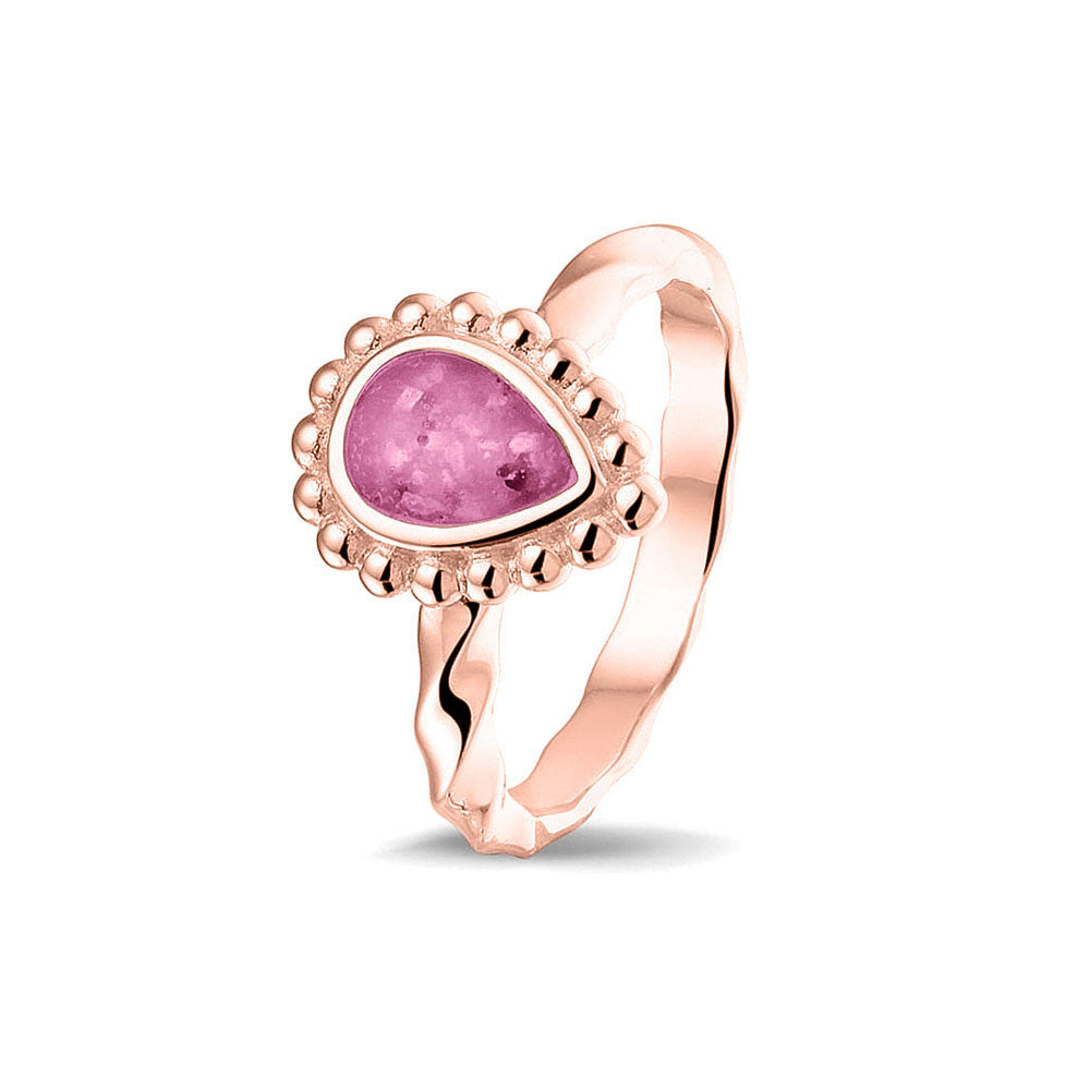 Gedenksieraad, asring met gedraaide scheen waar aan de bovenzijde in druppelvorm met parelrand zichtbaar as of haar (of eventueel melktandjes of moedermelk) verwerkt wordt.fluo